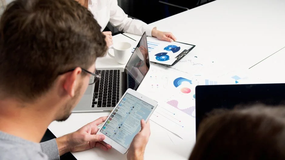 Focused business analysis with charts and graphs on a laptop in a modern office setting.